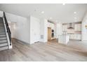 Open-concept floor plan with a staircase leading to the upper level, wood floors, and a modern kitchen at 8245 Butte Creek St, Littleton, CO 80125