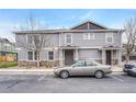 Exterior view of a well-maintained townhome with stone accents, featuring a car in the parking area at 17271 Waterhouse Cir # A, Parker, CO 80134