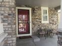 Welcoming front porch featuring a secure entry door, stone accents, and cozy seating area at 7456 E 10Th Ave, Denver, CO 80230