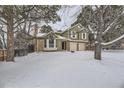 Two-story house with brick and siding, two-car garage, and snowy yard at 223 Durham Ct, Castle Pines, CO 80108