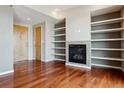 Open living room featuring hardwood floors, a fireplace and built-in shelving at 2900 W 44Th Ave # 301, Denver, CO 80211