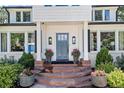 Inviting front entrance with stone steps, a gray door, manicured landscaping, and elegant light fixtures at 3500 S Franklin St, Englewood, CO 80113