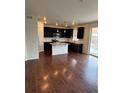Modern kitchen featuring dark cabinetry, granite countertops, and a large island with pendant lighting at 10611 Casper St, Parker, CO 80134