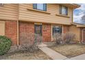 Inviting townhome entrance with brick accents, a well-lit entryway, and a neatly maintained front yard at 12407 E Louisiana Ave, Aurora, CO 80012