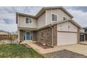Home with a two-car garage, brick accents, a well-maintained lawn, and a blue-green door at 18843 E Colorado Dr, Aurora, CO 80017
