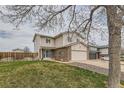 Two-story home with brick accents and a well-manicured lawn and mature trees at 18843 E Colorado Dr, Aurora, CO 80017