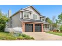 Side view of a two-story home with brick accents, a two-car garage, and a white picket fence at 3055 E 133Rd Cir, Thornton, CO 80241