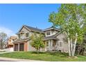Beautiful two-story house with gray siding, manicured lawn, and lovely trees enhancing the property's curb appeal at 3055 E 133Rd Cir, Thornton, CO 80241
