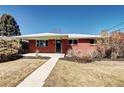 A single-story red brick home with well-kept bushes, set against a clear blue sky at 2921 E Colorado Ave, Denver, CO 80210