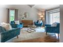Cozy living room featuring hardwood floors, comfortable seating, and a stylish round mirror at 8140 S Storm King Peak, Littleton, CO 80127