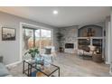 Comfortable living room with a stone fireplace, built-in shelving, and a sliding glass door to backyard at 11645 Lincoln St, Northglenn, CO 80233