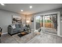 Inviting living room featuring light gray walls, wood-look floors, and sliding glass doors to backyard at 11645 Lincoln St, Northglenn, CO 80233