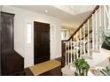 Inviting foyer with a dark wooden door, hardwood floors, and a staircase leading to the upper level at 11506 Greenbriar Ln, Parker, CO 80138