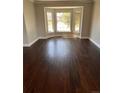 Bright living room featuring dark wood floors and a large bay window at 11506 Greenbriar Ln, Parker, CO 80138