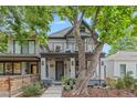 Charming home with a welcoming front porch, elegant columns, and a lush landscaped yard on a sunny day at 3410 Pecos St, Denver, CO 80211