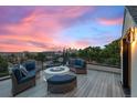 Rooftop deck with comfortable seating around a fire pit, offering stunning city views at sunset at 3410 Pecos St, Denver, CO 80211
