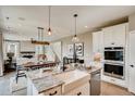 Open-concept kitchen with granite countertops, stainless steel appliances, and a view of the dining and living areas at 13794 Honey Hush Trl, Parker, CO 80134