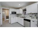 Beautifully remodeled kitchen with white cabinets, stainless steel appliances, and mosaic tile backsplash at 2202 S Grape St, Denver, CO 80222