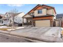 Two-story house with tan and burnt orange siding, attached garage, and landscaping at 11208 Eagle Creek Cir, Commerce City, CO 80022