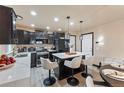 Modern kitchen with dark cabinetry, quartz countertops, and island seating at 11208 Eagle Creek Cir, Commerce City, CO 80022