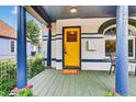 Inviting front porch featuring a yellow door, detailed columns, and a cozy seating area at 274 S Lincoln St, Denver, CO 80209