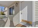 Close-up of the front porch with a classic white door, stylish lighting, and tidy landscaping at 20781 E 48Th Pl, Denver, CO 80249