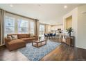 Bright living room with hardwood floors, a large window and open floor plan to kitchen at 9544 Pitkin St, Commerce City, CO 80022