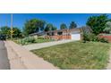 Well-maintained ranch-style home with a long driveway and lush green lawn at 6043 S Cody Way, Littleton, CO 80123