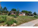 Lovely home with a green lawn, complemented by a small tree and a few garden areas at 6043 S Cody Way, Littleton, CO 80123