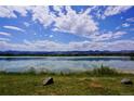 Scenic lake view reflecting blue skies and clouds in a peaceful natural setting at 6043 S Cody Way, Littleton, CO 80123