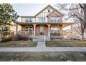 Charming two-story brick home with a welcoming front porch and well-maintained landscaping at 8645 Coors St, Arvada, CO 80005