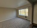 Inviting living room with plush carpeting and large windows providing ample natural light at 13031 Dexter St, Thornton, CO 80241