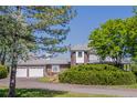 Charming home featuring a brick exterior, multiple garages, and mature trees at 14447 Madison St, Thornton, CO 80602