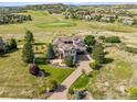 Expansive home overlooks a golf course with lush greenery, complemented by a long driveway and well-manicured grounds at 5192 Sedona Dr, Parker, CO 80134