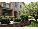 Charming two-story home showcasing a stone facade, arched entryway, well-maintained landscaping, and a welcoming front entrance at 4500 E Louisiana Ave, Denver, CO 80246