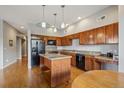 Modern kitchen featuring wood cabinets, granite counters, stainless steel appliances and a center island at 1057 W Century Dr # 112, Louisville, CO 80027