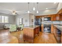 Open kitchen and living area featuring modern appliances, wood cabinets, and a center island at 1057 W Century Dr # 112, Louisville, CO 80027
