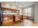 Bright kitchen featuring wood cabinets, granite counters, stainless steel appliances and a center island at 1057 W Century Dr # 112, Louisville, CO 80027