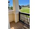 Covered porch with wood railing and a view of the green common area at 1368 Royal Troon Dr, Castle Rock, CO 80104