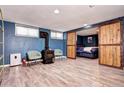 Cozy basement room featuring a wood-burning stove and sliding barn doors to the bedroom at 715 Zang St, Lakewood, CO 80401