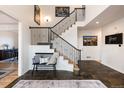 Inviting foyer with slate tile flooring, a staircase with iron railing, and a bench seating area at 7965 S Titus Ct, Aurora, CO 80016