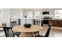Open dining and kitchen area with wood floors and a modern wood table at 1617 S Quitman St, Denver, CO 80219