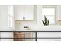 Modern kitchen with white countertops, white cabinets and a tiled backsplash at 1617 S Quitman St, Denver, CO 80219