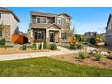 Beautiful two-story house with a stone and siding exterior, walkway, and meticulous landscaping at 6833 Longpark Dr, Parker, CO 80138
