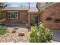 Close up of a brick home entrance with decorative plants and a well-kept garden at 9386 W Geddes Pl, Littleton, CO 80128