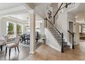 Bright entryway with staircase, and adjacent formal dining room with large windows at 13850 Meadowbrook Dr, Broomfield, CO 80020