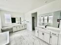 Spacious bathroom features dual vanities, soaking tub, marble floors, and contemporary fixtures for a spa-like experience at 16521 Black Rose Cir, Parker, CO 80134
