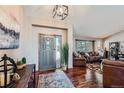 Inviting foyer with hardwood floors, stylish rug, decor and an open view of the living area at 1742 Rosemary Dr, Castle Rock, CO 80109