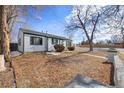 Quaint home with a spacious front yard, trees, and a decorative concrete border at 1100 Hillside St, Aurora, CO 80010