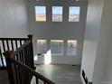 Bright great room with tall windows, wood floors, fireplace, and dark brown stair railing at 9354 Quartz St, Arvada, CO 80007